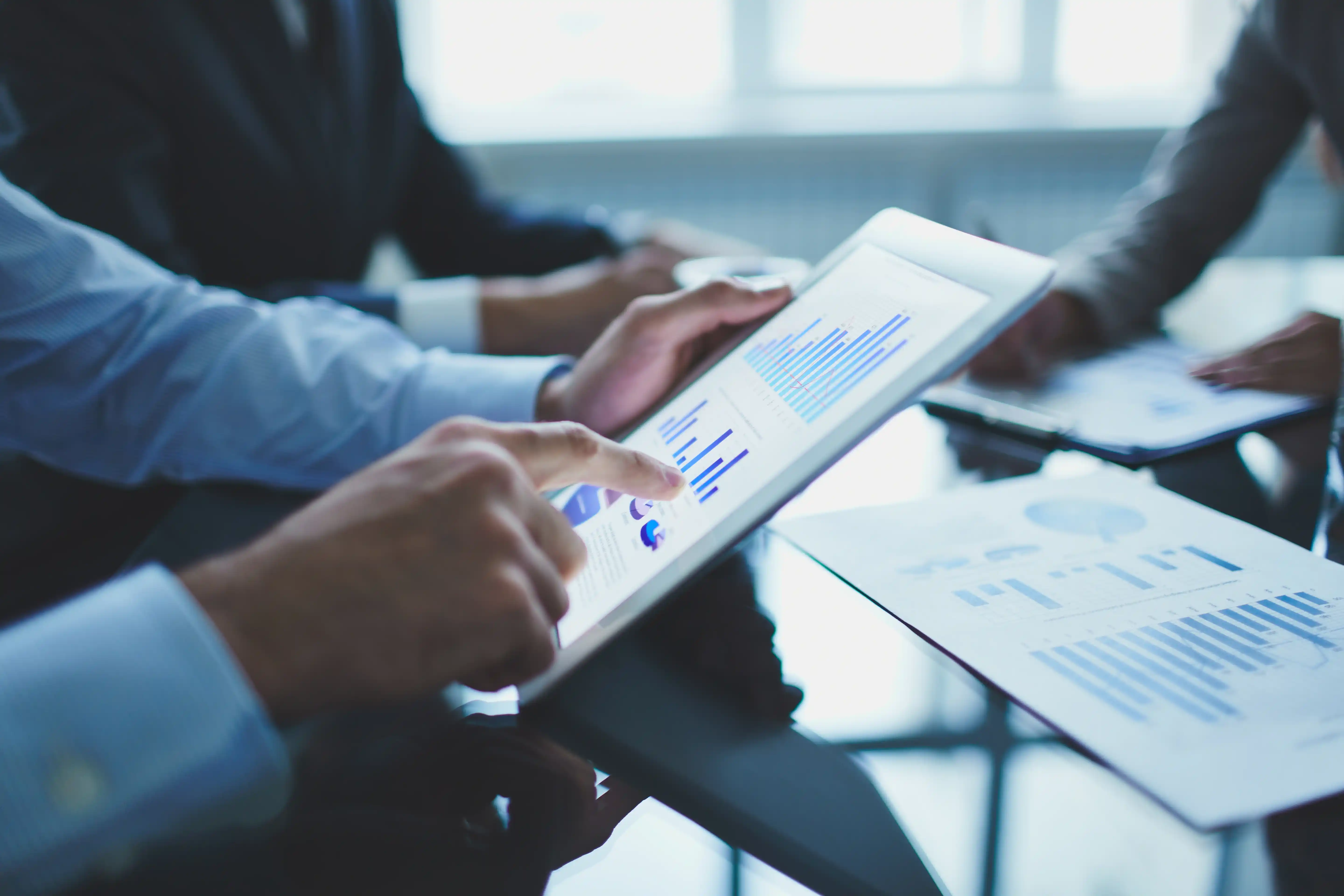 three persons researching statistics, schemes and other investment data